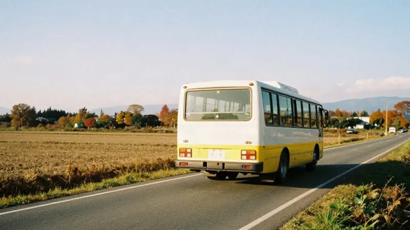 A local bus on a road through fields